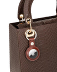 Leather air tag holder, tan, on a bag