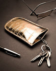 Leather key case with squeeze spring opening, gold croc, lifestyle