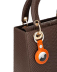 Leather air tag holder, orange, on a bag