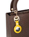 Leather air tag holder, yellow, on a bag