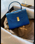 Leather top handle bag, cobalt croc, unwrapping