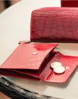 Leather purse with brass clasp, red croc, lifestyle