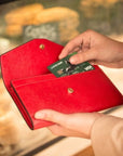 Leather accordion clutch purse with 12 card slots, red saffiano, lifestyle