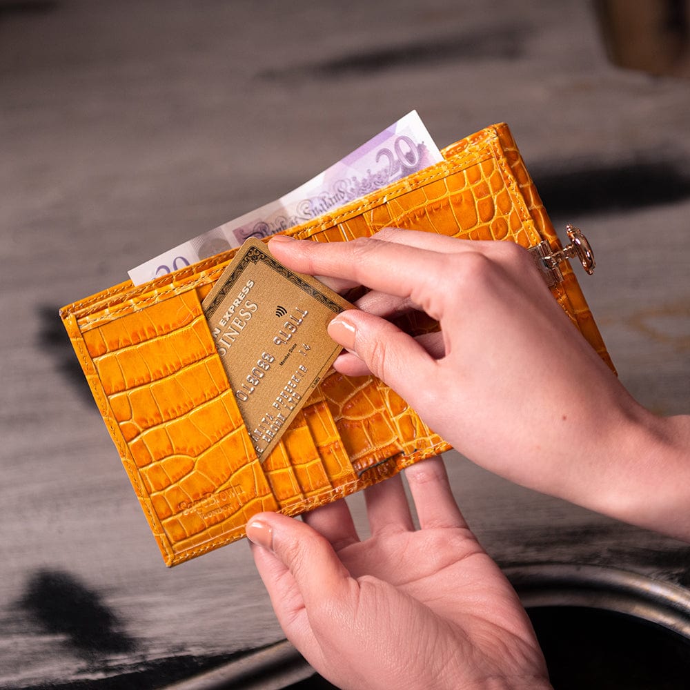 Leather purse with brass clasp, yellow croc, lifestyle