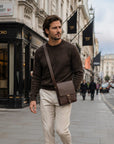 Men's leather messenger bag with strap, lifestyle