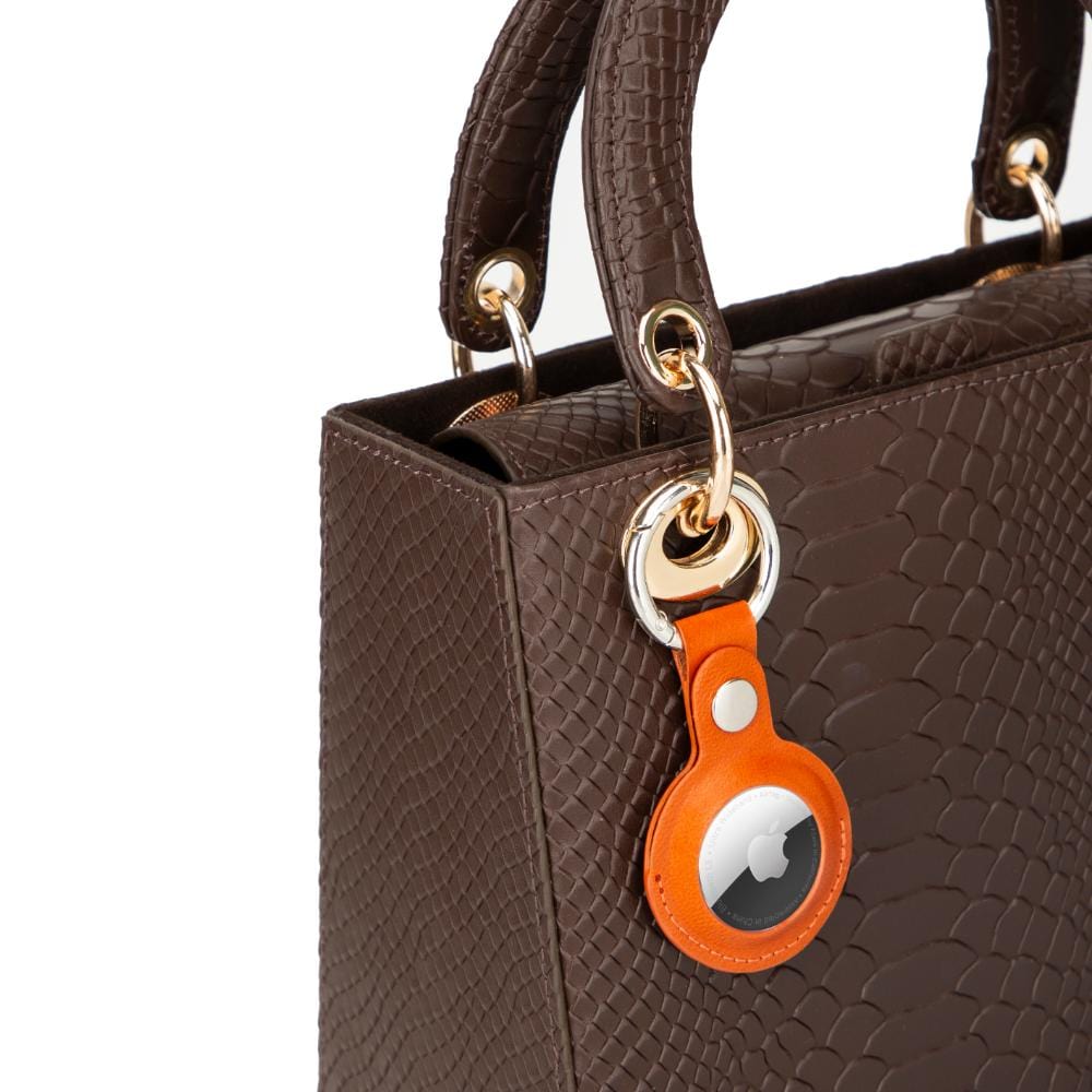 Leather air tag holder, orange, on a bag