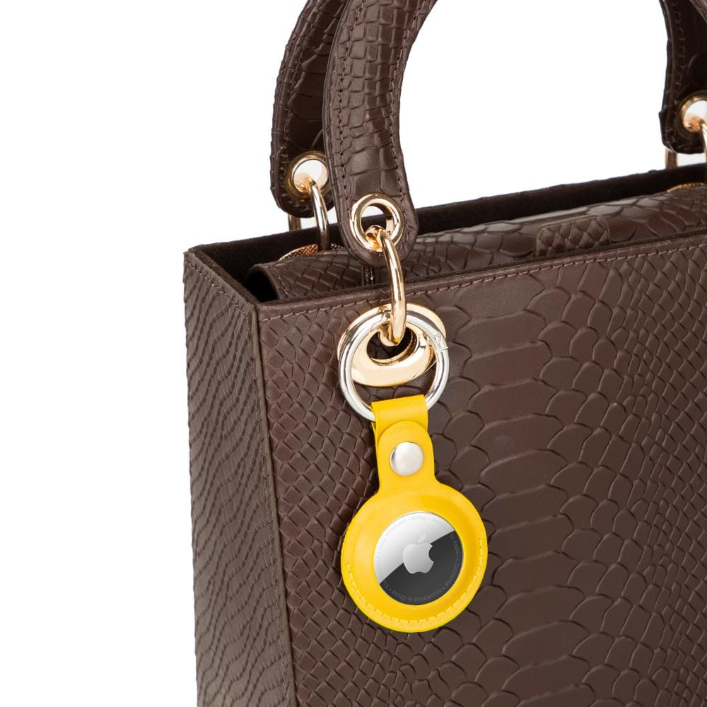 Leather air tag holder, yellow, on a bag