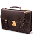 Leather satchel briefcase with straps and brass lock, brown, side