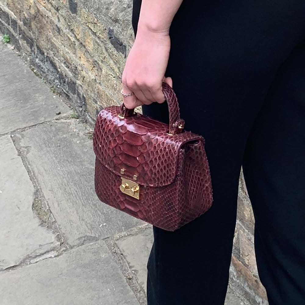 Small real python top handle bag, burgundy, lifestyle