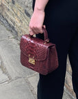 Small real python top handle bag, burgundy, lifestyle