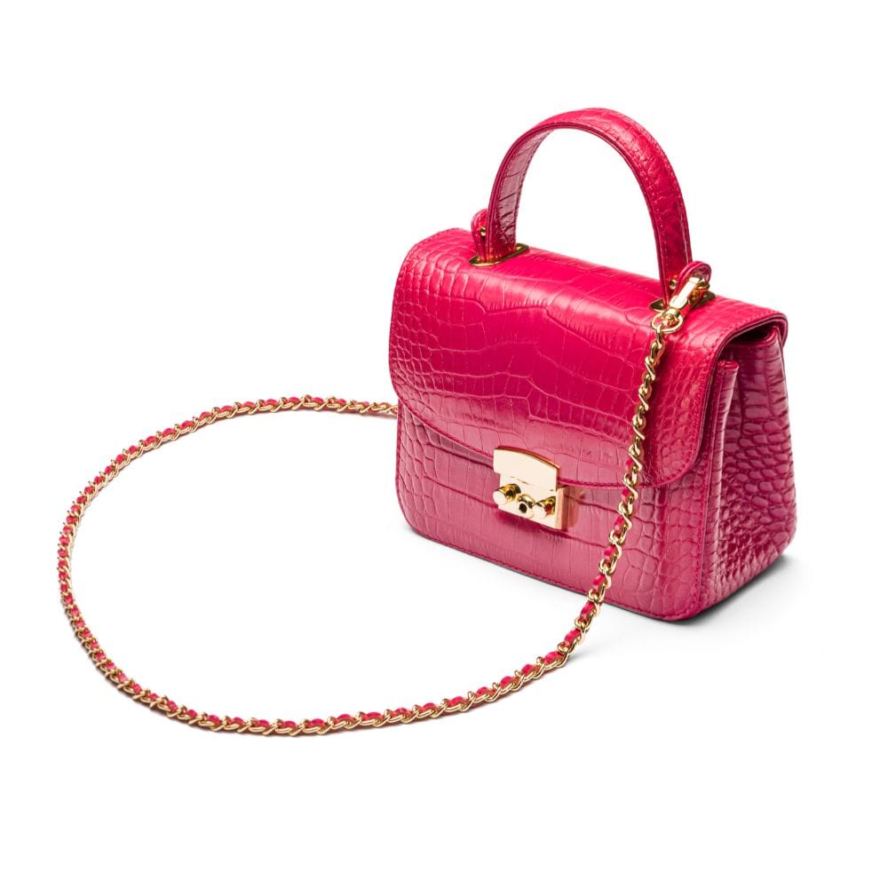 Small leather top handle bag, pink croc, side view