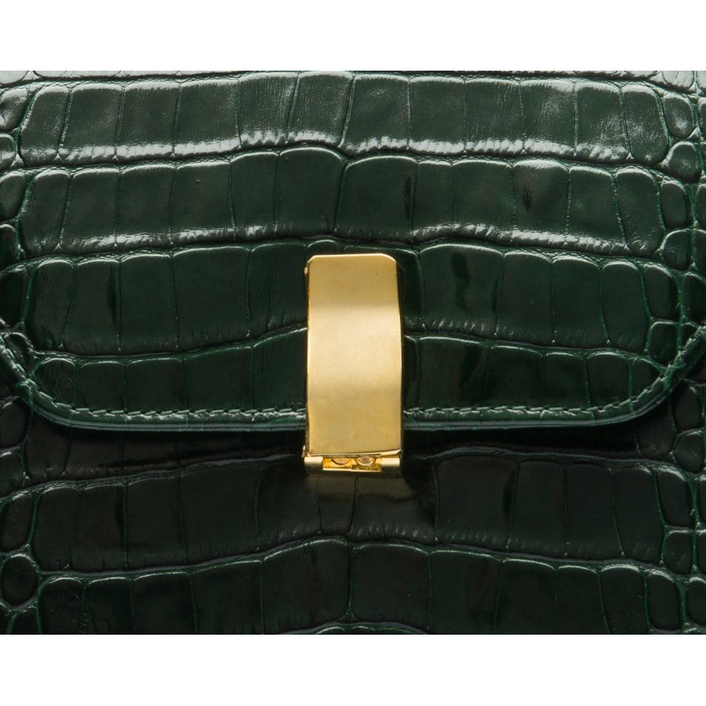Leather top handle bag, green croc, closeup of the clasp