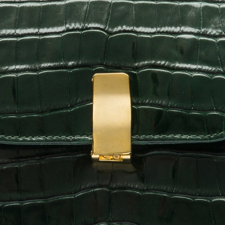 Leather top handle bag, green croc, closeup of the clasp