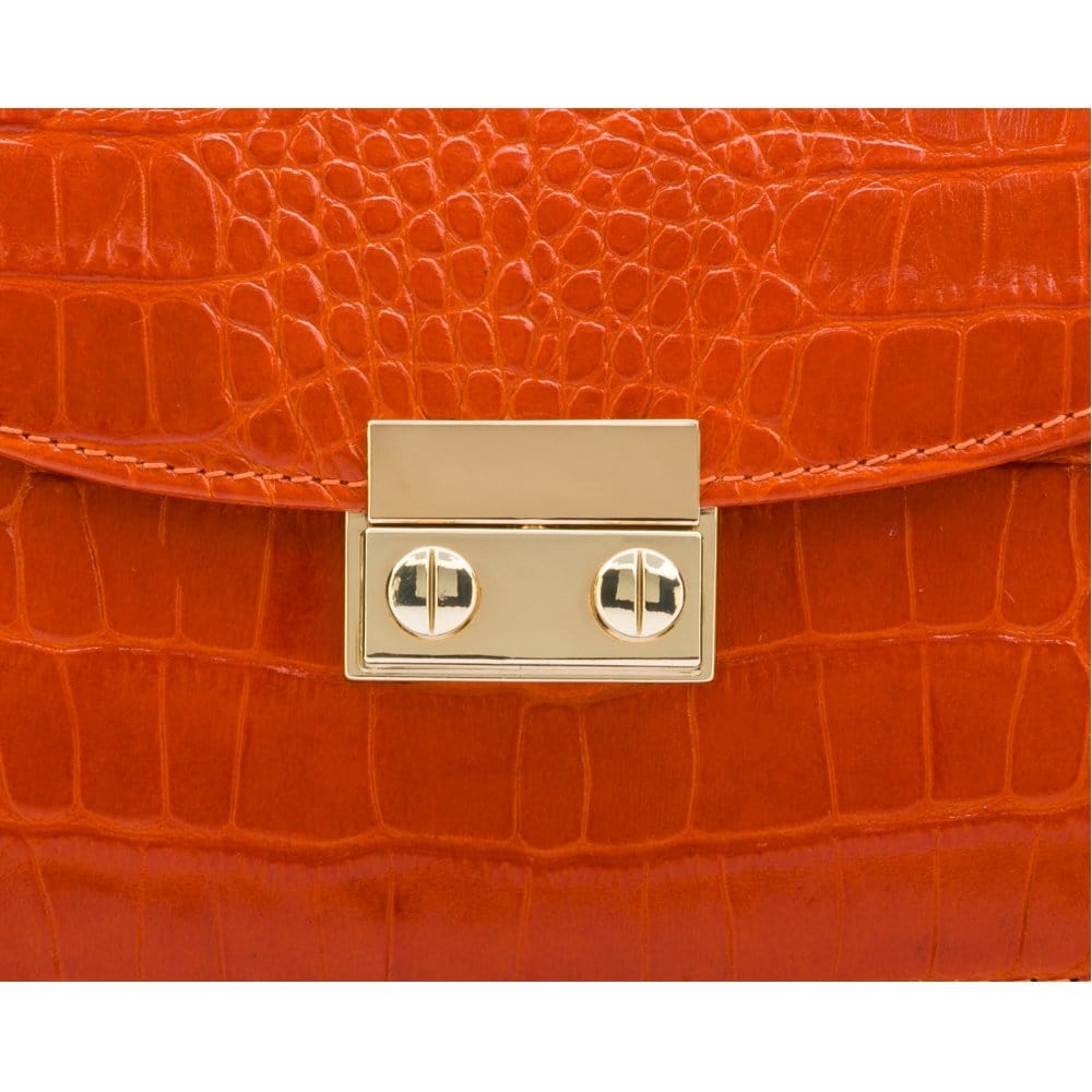 Small leather top handle bag, orange croc, lock close up