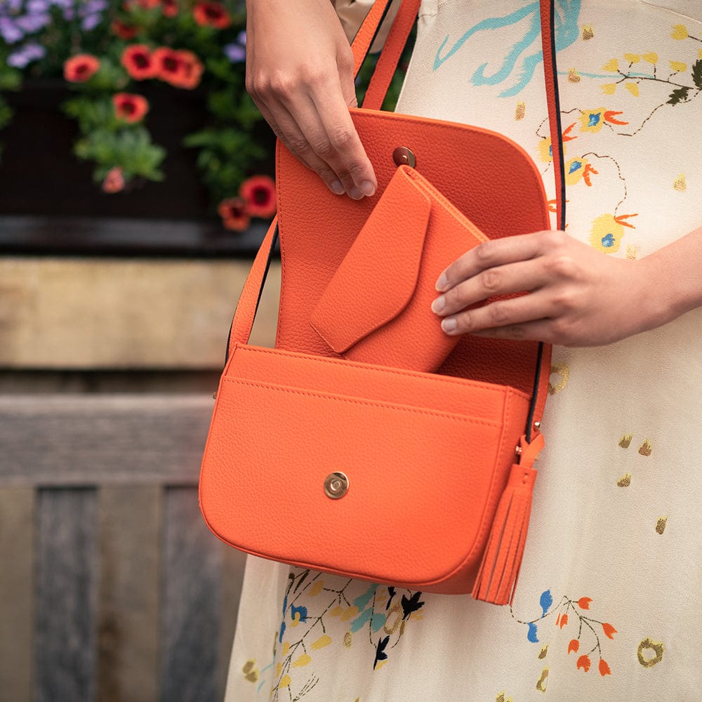 Large leather purse with 15 CC, orange pebble grain, lifestyle