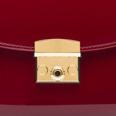 Small leather top handle bag, red patent, lock close up