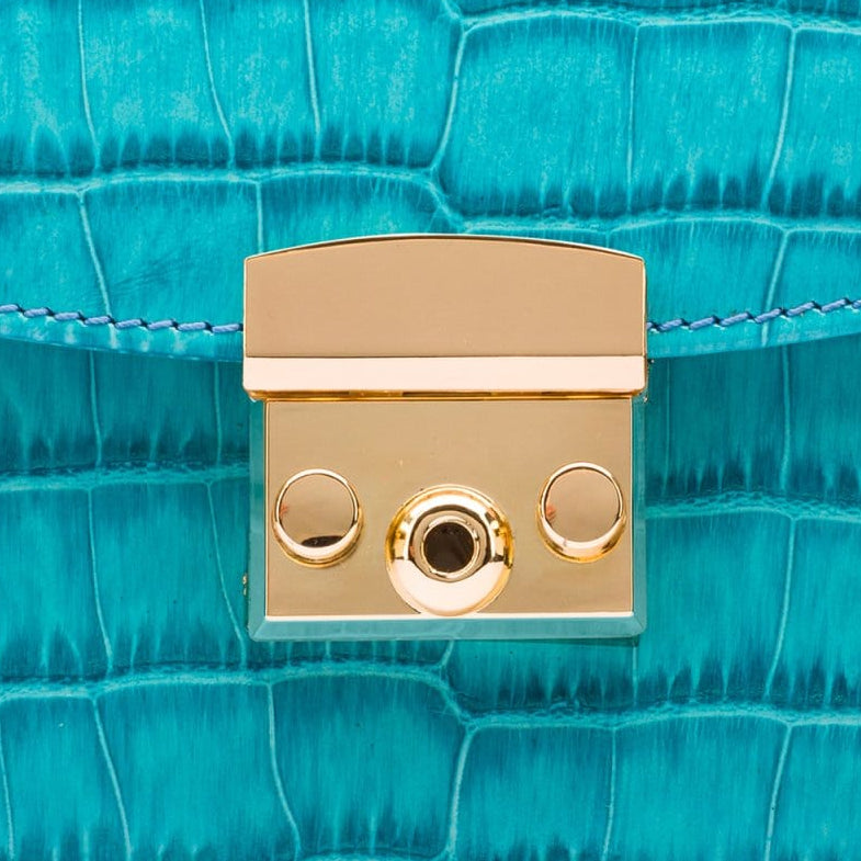 Small leather top handle bag, turquoise croc, lock close up