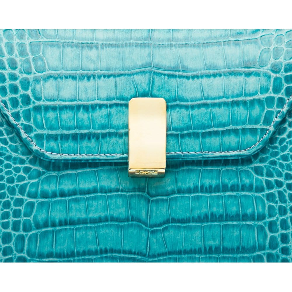 Leather top handle bag, turquoise croc, lock closeup