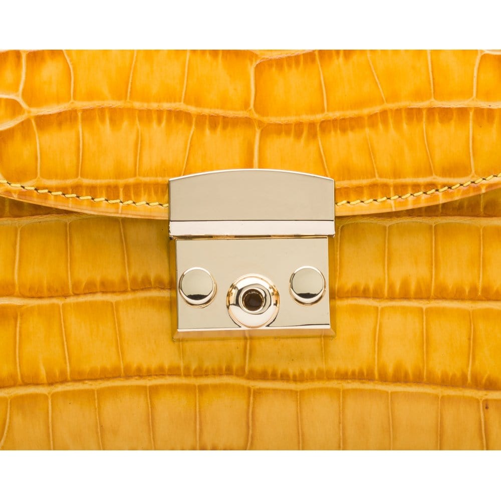Small leather top handle bag, yellow croc, lock close up