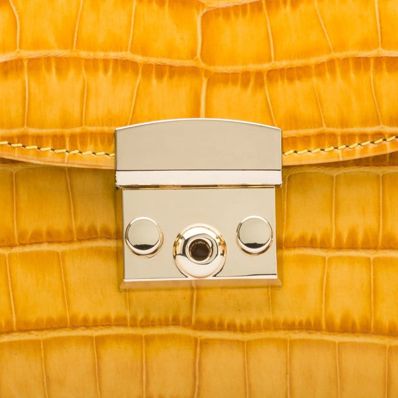 Small leather top handle bag, yellow croc, lock close up