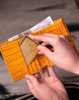 Leather purse with brass clasp, yellow croc, lifestyle